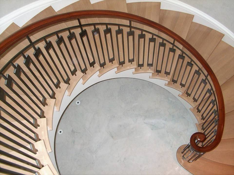 A spiral staircase in a house with wooden railings.
